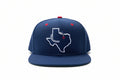 A navy blue fitted hat with a white Texas logo and a red dot on the brim.